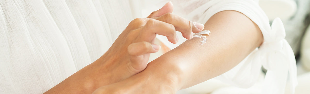 picture of a hand applying a cream on the arm