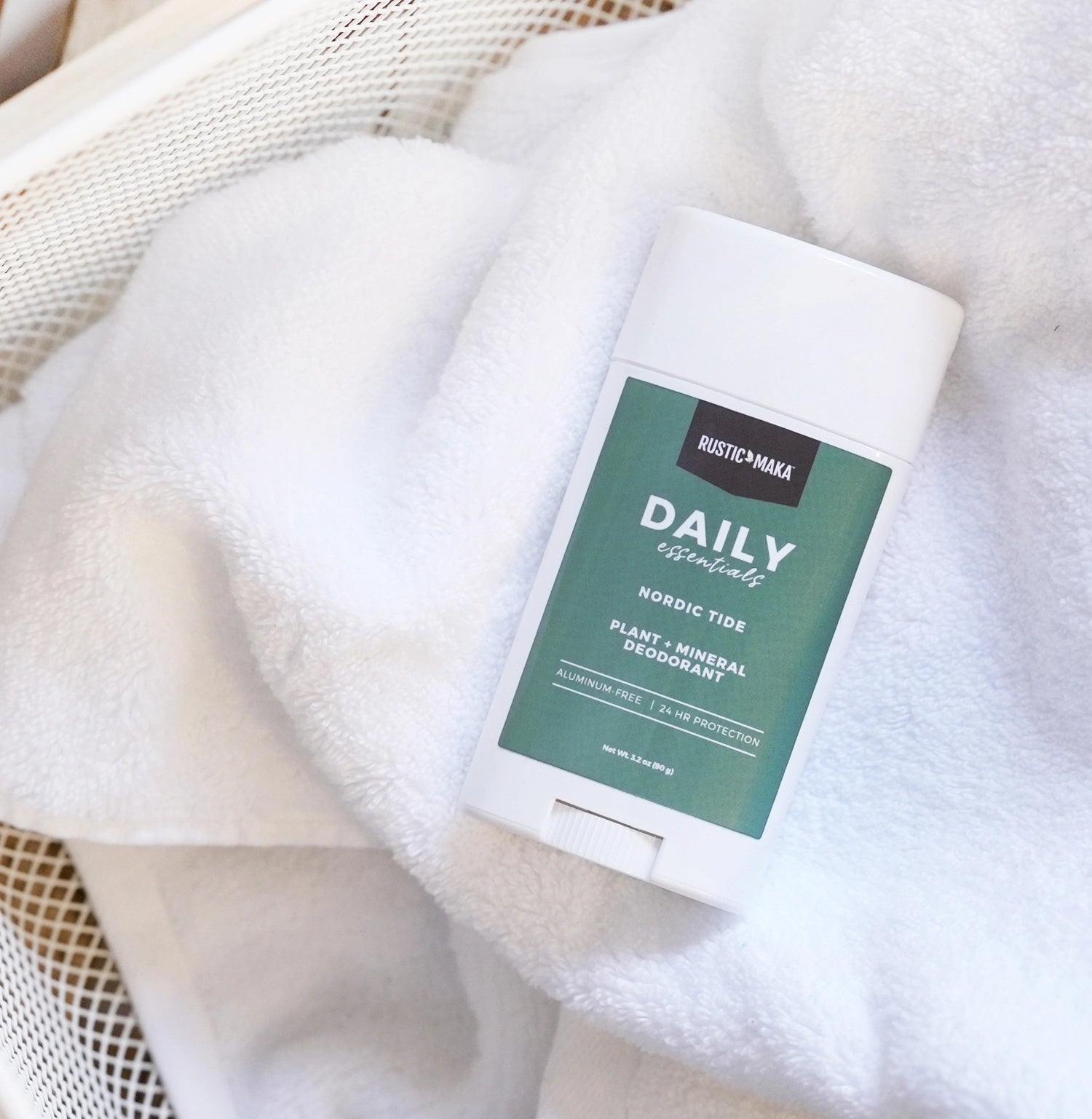 Deodorant stick with a green label on a textured white surface