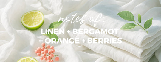 Stack of white fabric with lime, berries, and leaves on a light background with text 'notes of linen + bergamot + orange + berries'.