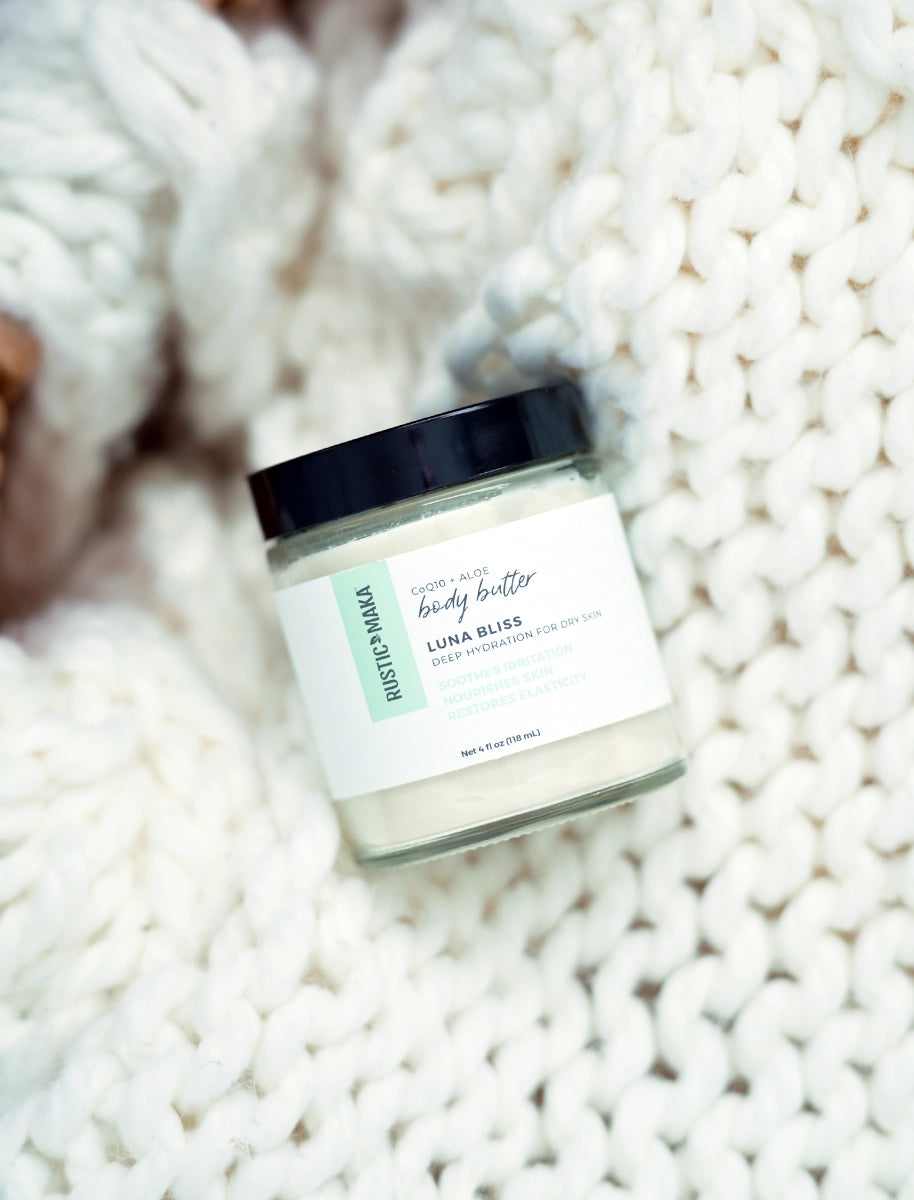 Jar of Luna Bliss body butter on a textured white surface