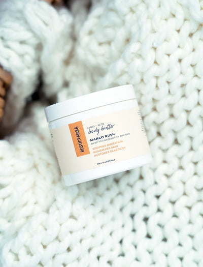 Body butter container labeled 'Mango Rush' on a textured white surface