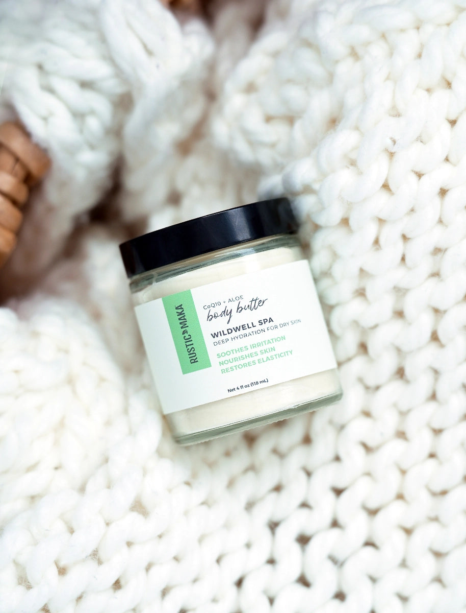 Jar of body butter on a textured white surface